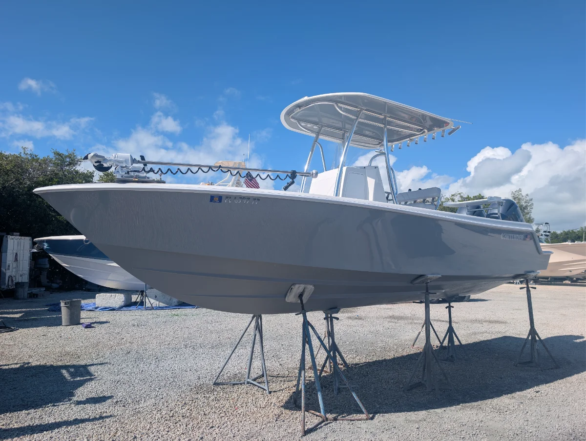 Center-console boat with a coated hull, on stands at the yard