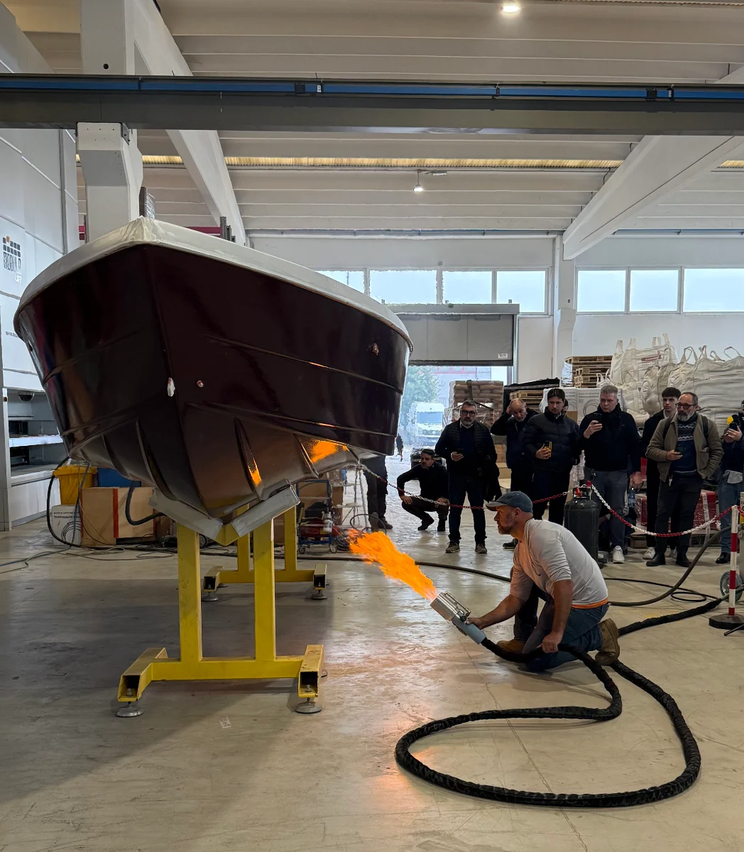 Technician thermal-applying the polymer coating to a boat hull